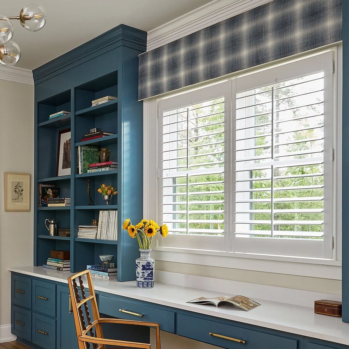 Plaid cornice above plantation shutters in a home office, available from Window Coverings by Julie